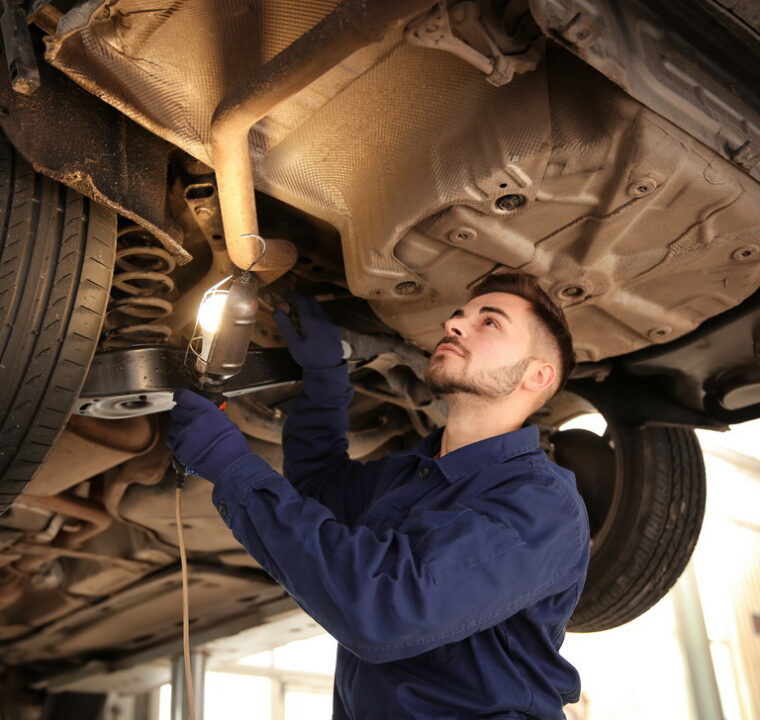Technician checking modern car at automobile repair shop